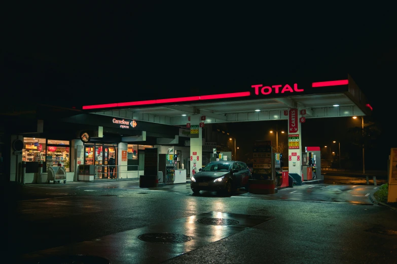 a small car is stopped at a gas station