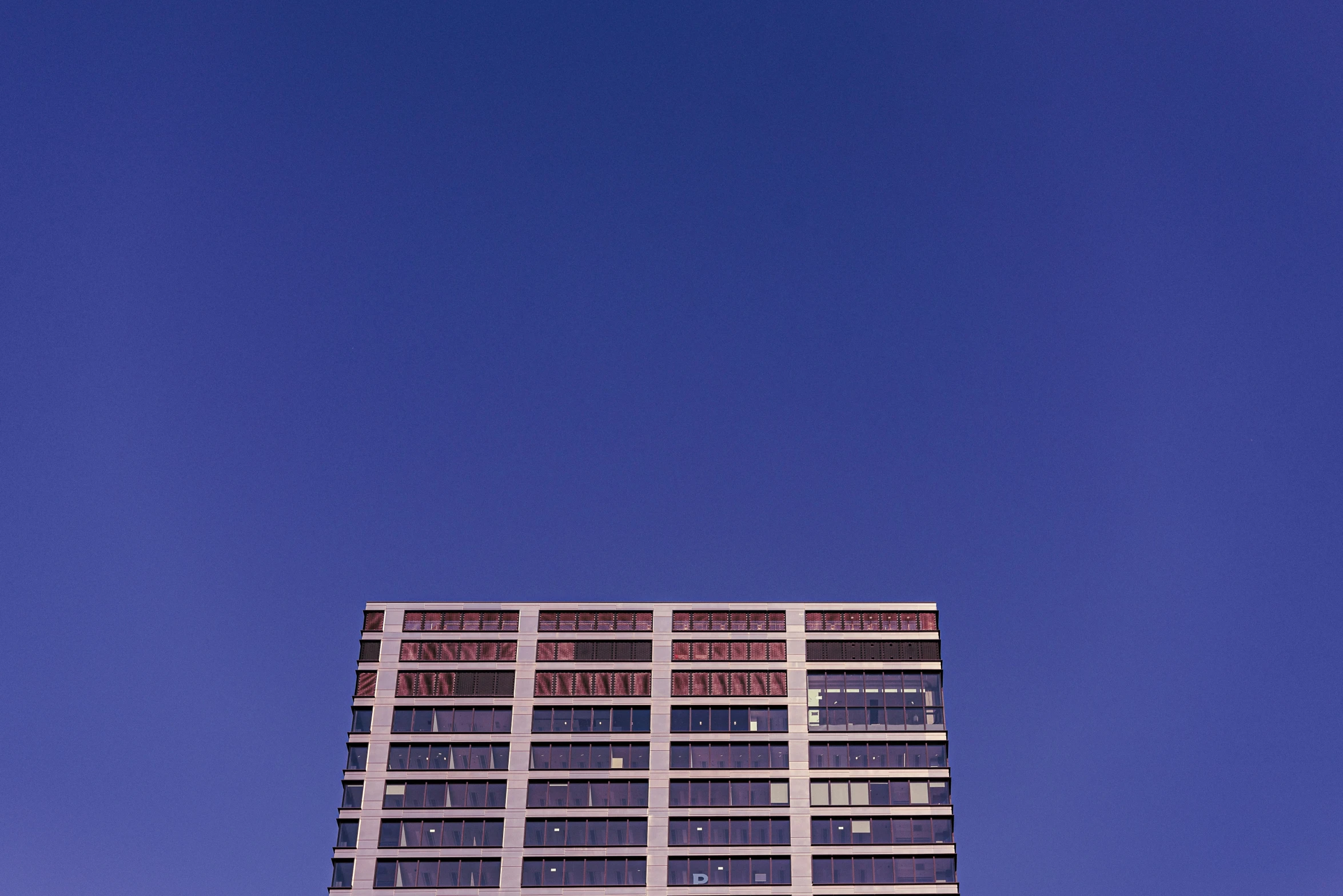 an airplane flying above a building and sky