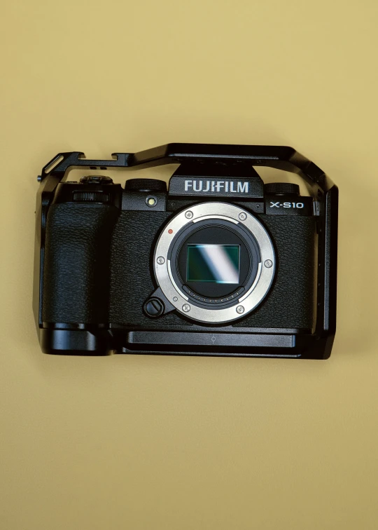 a small camera on display in front of a beige wall