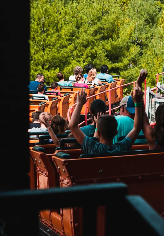 a view from a window of people sitting in seats at an amut park