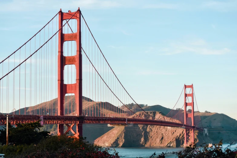 a large red suspension bridge crossing a body of water