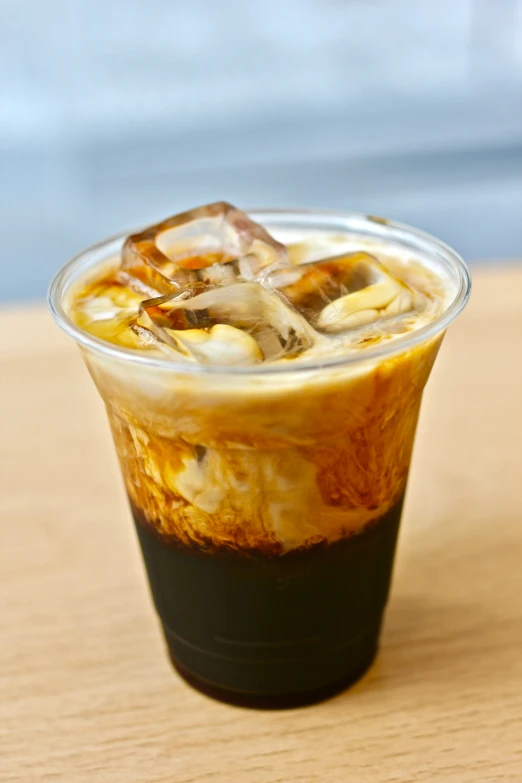 ice and bananas in a plastic cup sitting on a wooden table