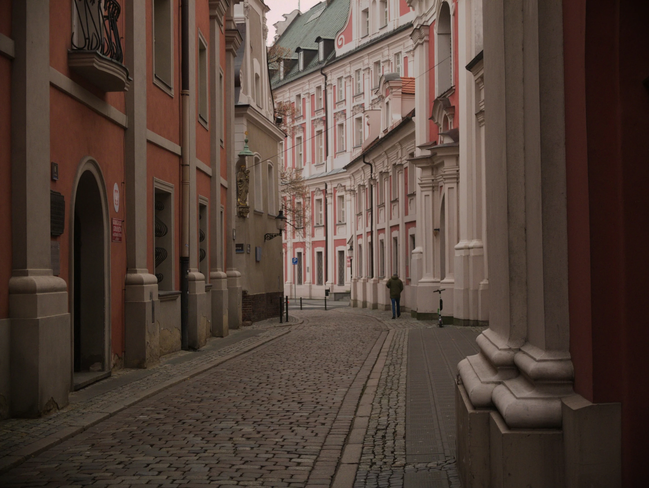 a narrow brick street with old buildings on either side