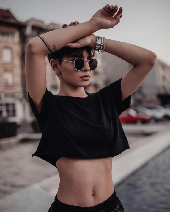 a woman in a black crop top and sun glasses