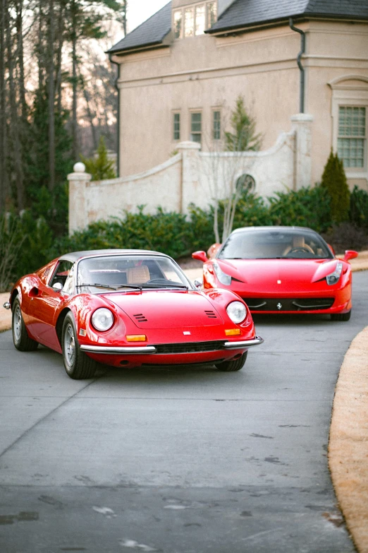 red sport cars in the street in front of a house