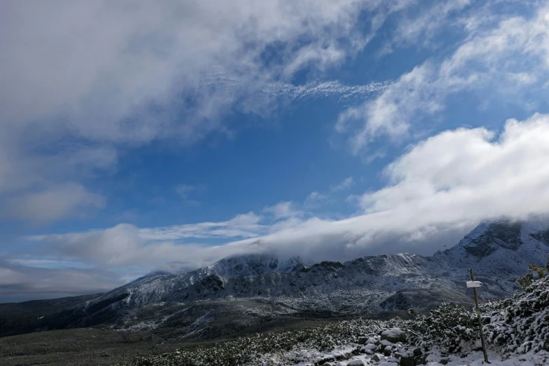 the view from atop the mountain with a few clouds coming in