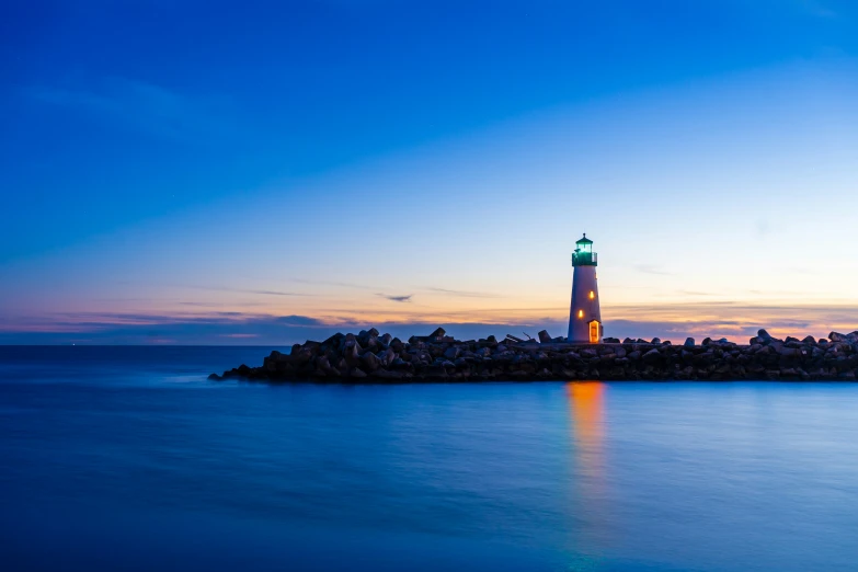 a very small light house sitting by the ocean