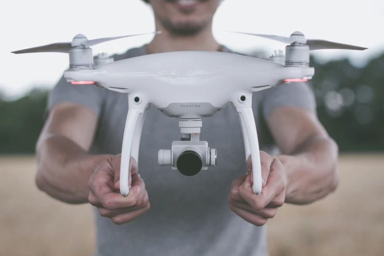 a man is holding a camera controlled quadcopter