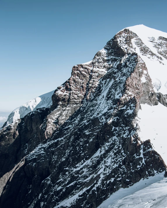 a mountain range covered in snow with mountains on one side and a cloudy sky