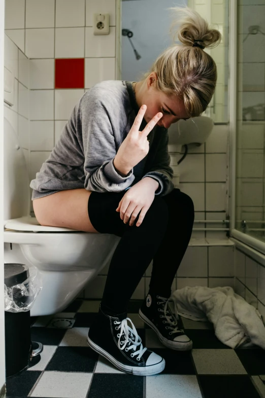 a woman sitting on a toilet in a bathroom