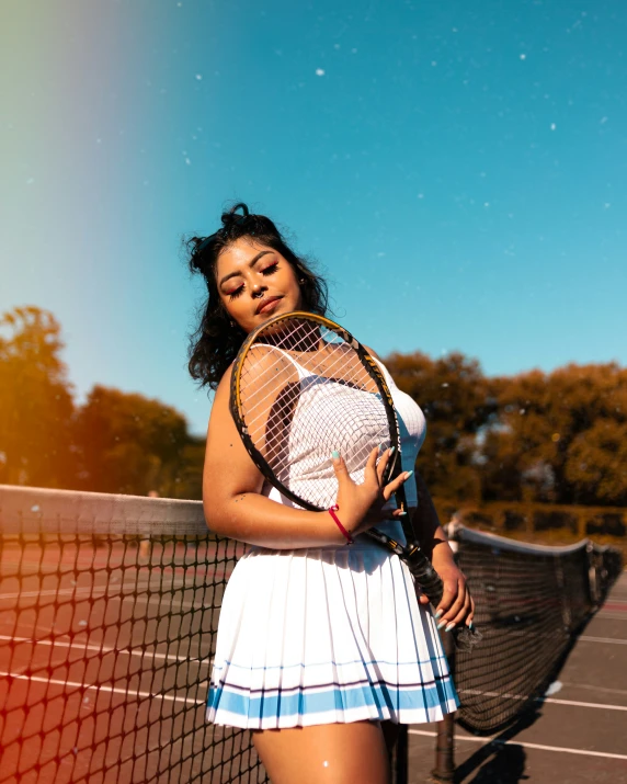 an athletic female poses on a tennis court