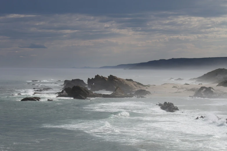 an ocean with several rocks sticking out of the water