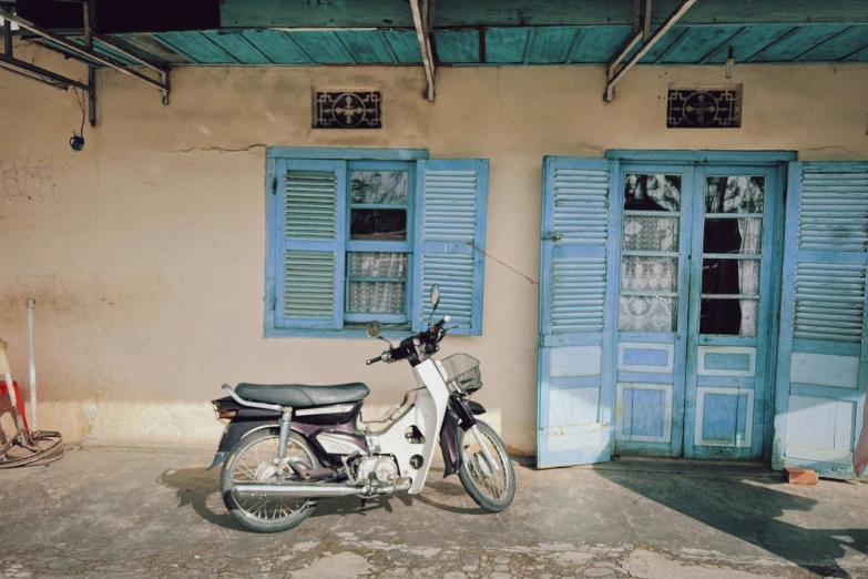 an old motorcycle is parked outside a house