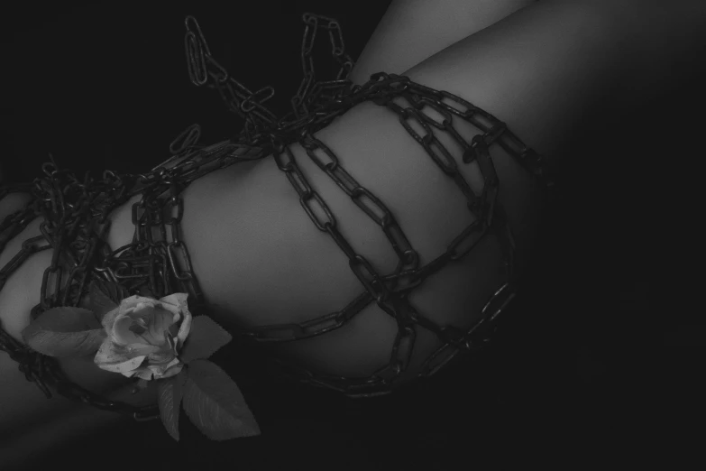 there is a rose tied in chains to an arm
