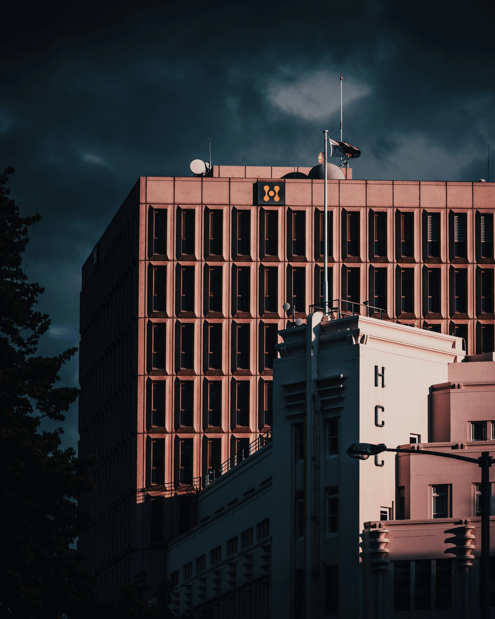 a very tall building with a clock in front of some clouds