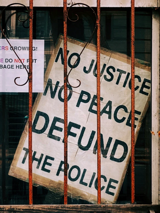 a sign saying no justice, no peace behind the bars