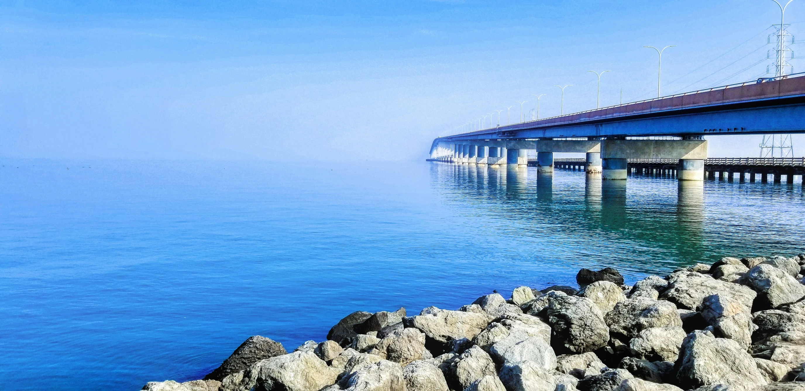 view from shore near a long bridge over water