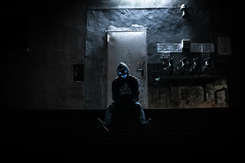 a man sitting in front of a doorway on the side walk