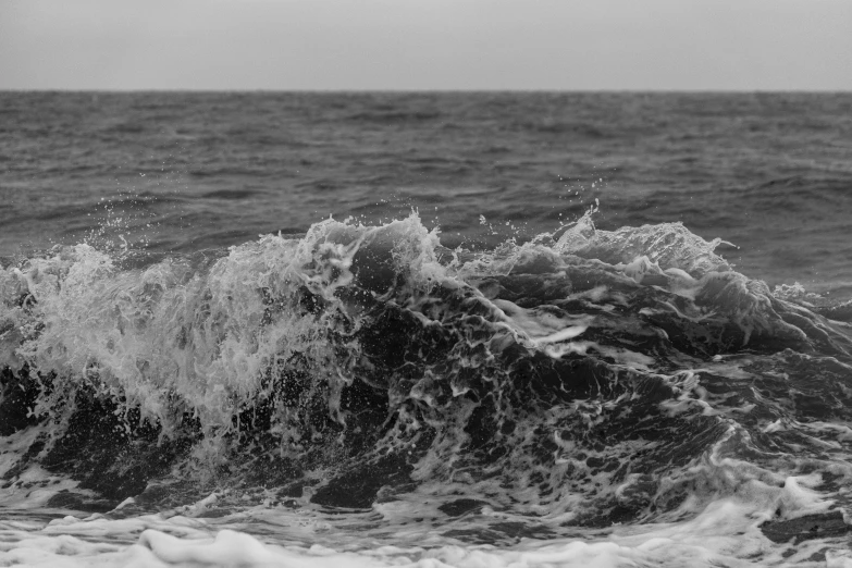 there is an ocean waves breaking against the rocky shoreline