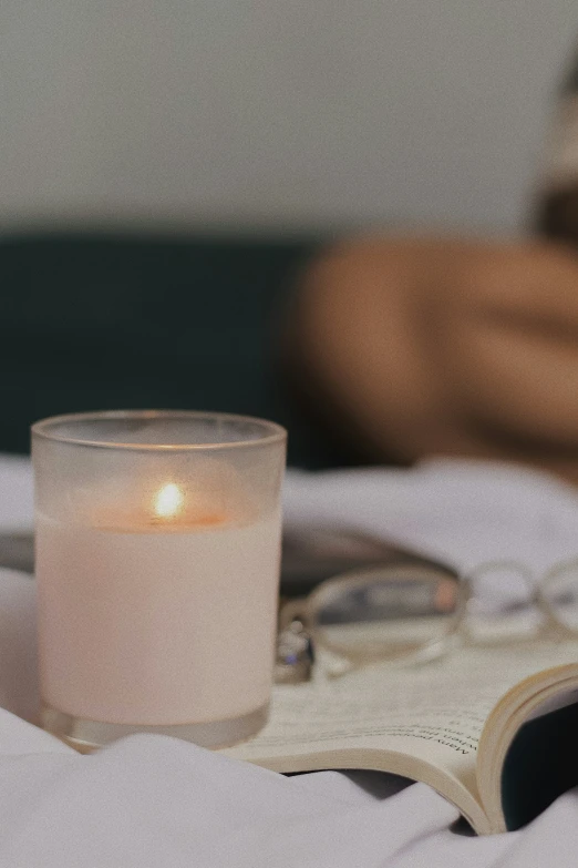 the glass has a candle on it near books