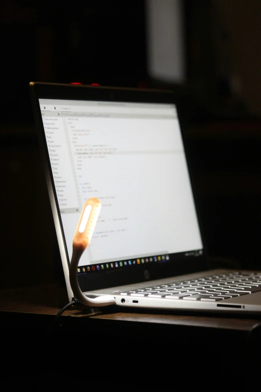a close - up image of a laptop in the dark with a mouse on its keyboard