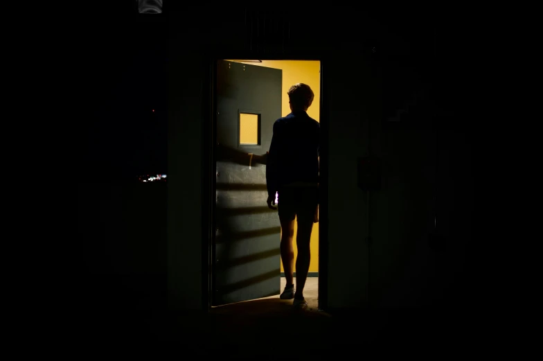 a man is entering a dimly lit room at night