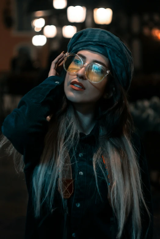 a woman wearing sunglasses and a headwrap poses for a po