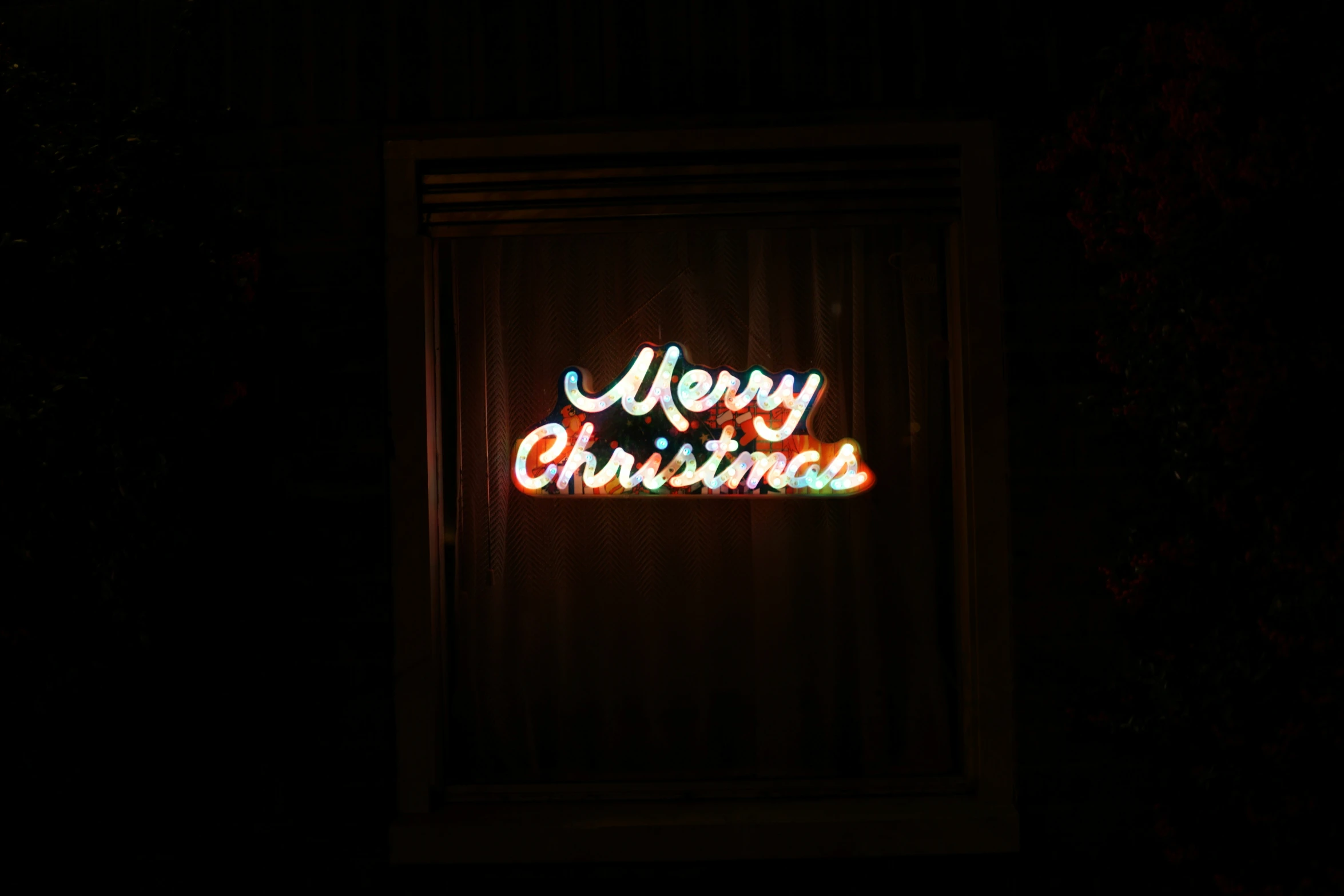 a christmas message projected on a screen in the dark