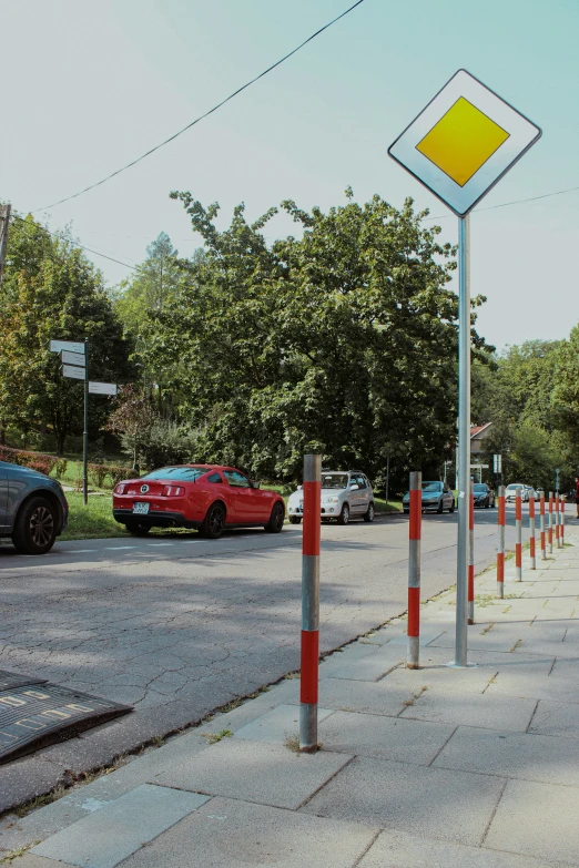 a parking lot with a yellow and white sign next to a red car