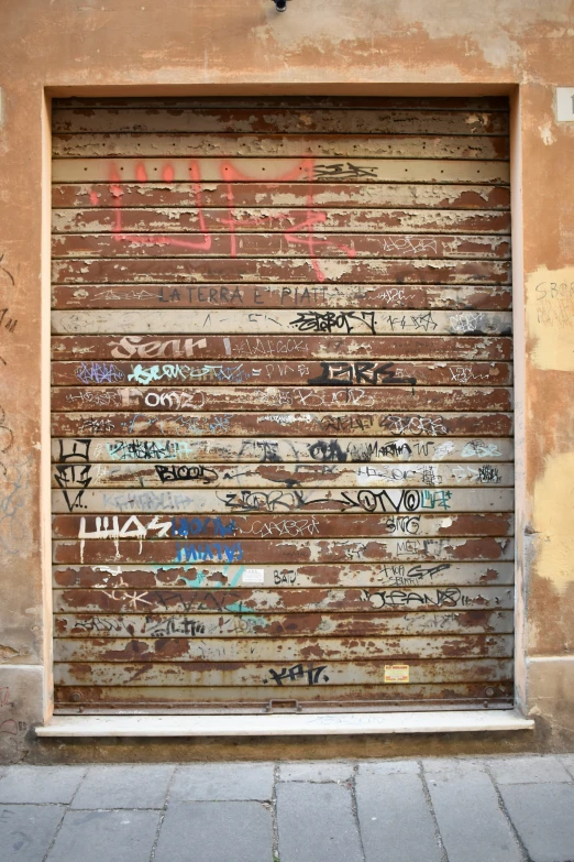 a closed garage door is covered with graffiti