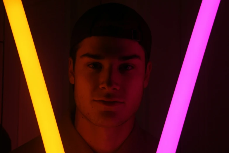 a young man is holding neon sticks in his hands