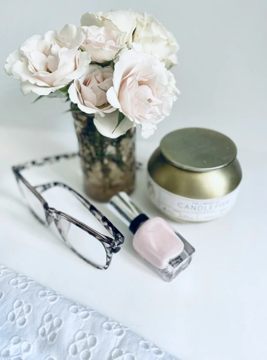 a pink flower and glasses are on the table