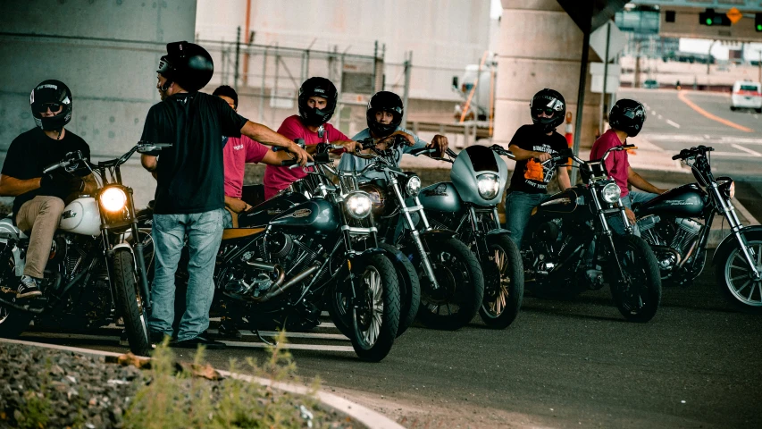 a group of motorcycle riders riding down the street together