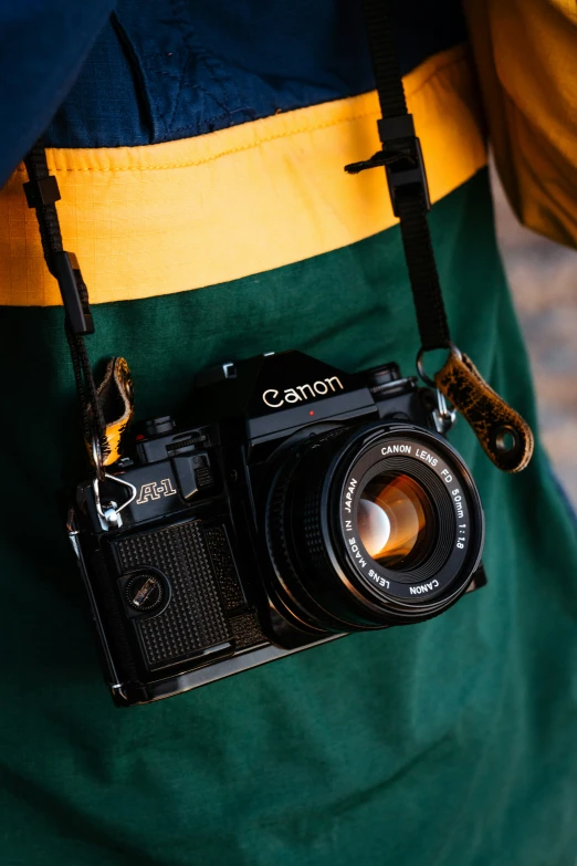 a man wearing a green and yellow vest holding a camera