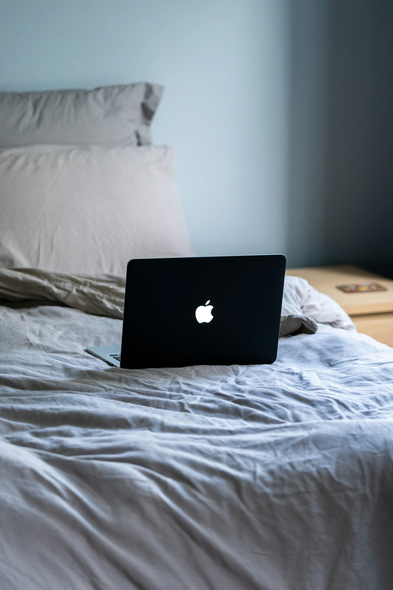 a mac laptop sitting on top of a bed