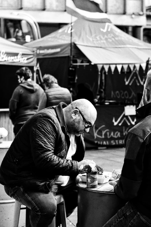 two men sitting at a table eating food