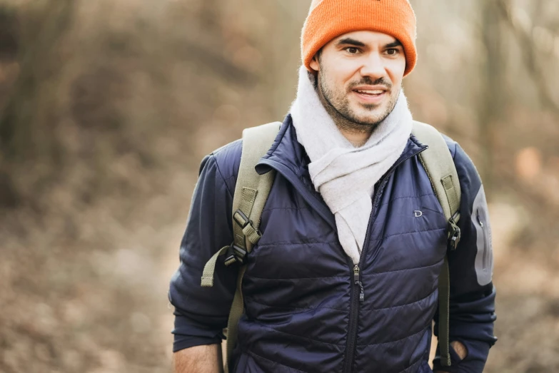 a man wearing a backpack wearing an orange hat