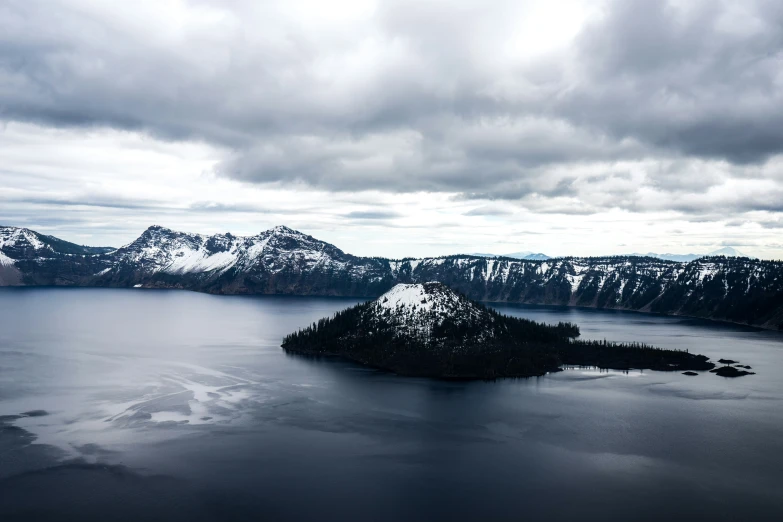 snow covered mountains surrounding the large body of water