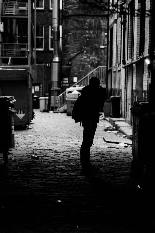 silhouette of a man walking down the sidewalk of an urban area