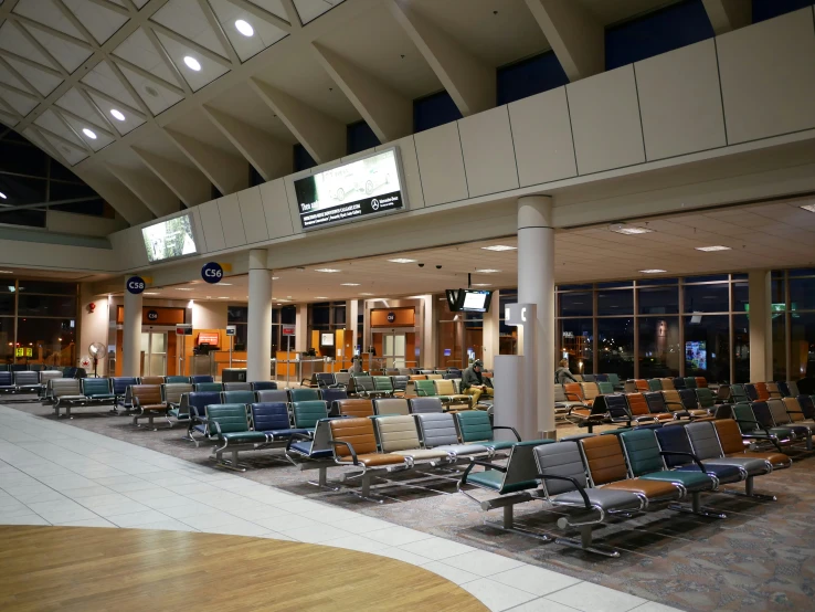 empty chairs sitting in an airport lobby during the night