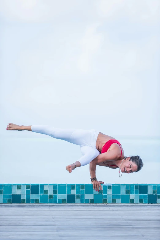 a woman performing a handstand on the beach