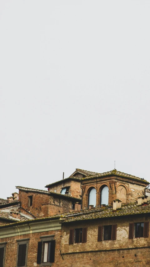 an airplane is flying near two buildings on a cloudy day