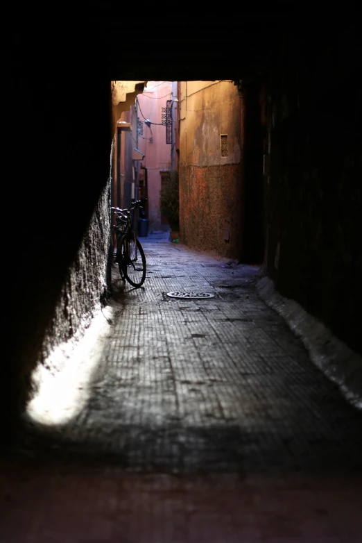 the bike is resting in the alley under the light