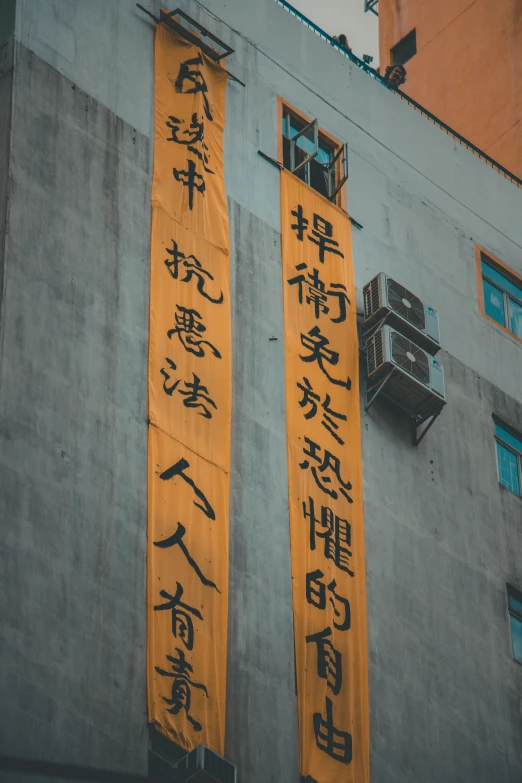 some chinese writing hanging off the side of a building