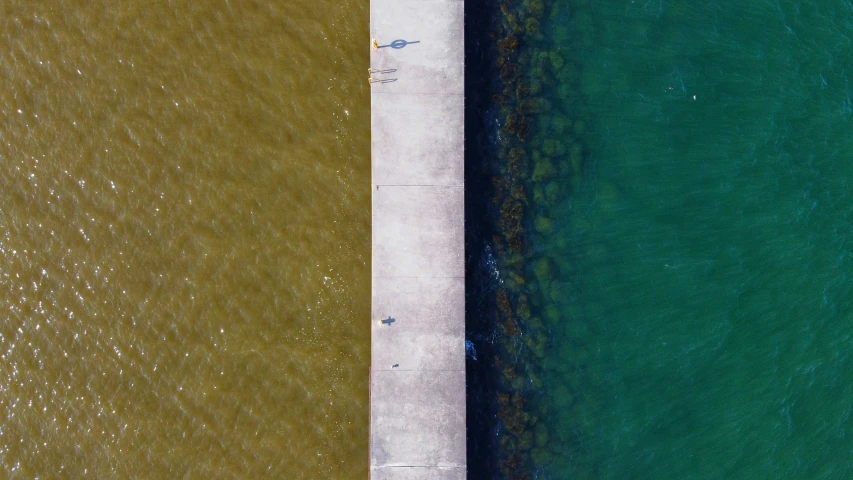 two water colored piers next to each other and a boat in the ocean