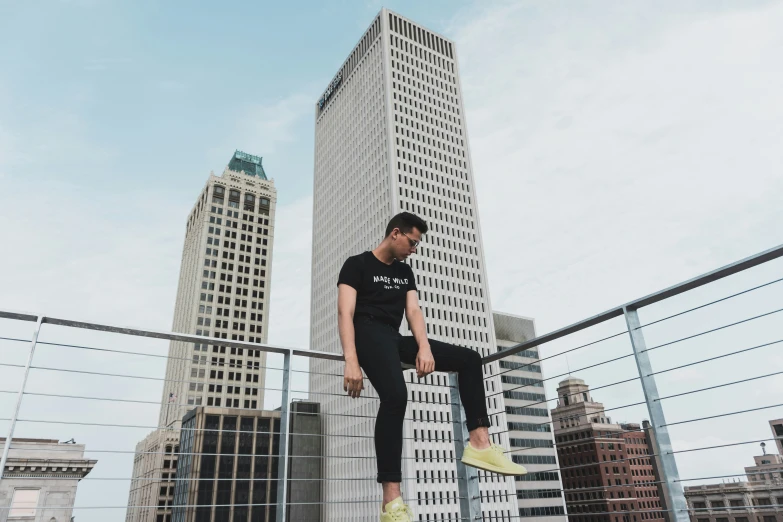 a young man jumps his skateboard against a fence in a city