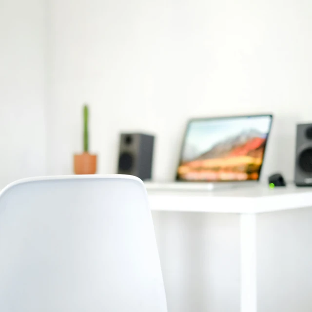 an office with a desk, computer, keyboard, and speaker system