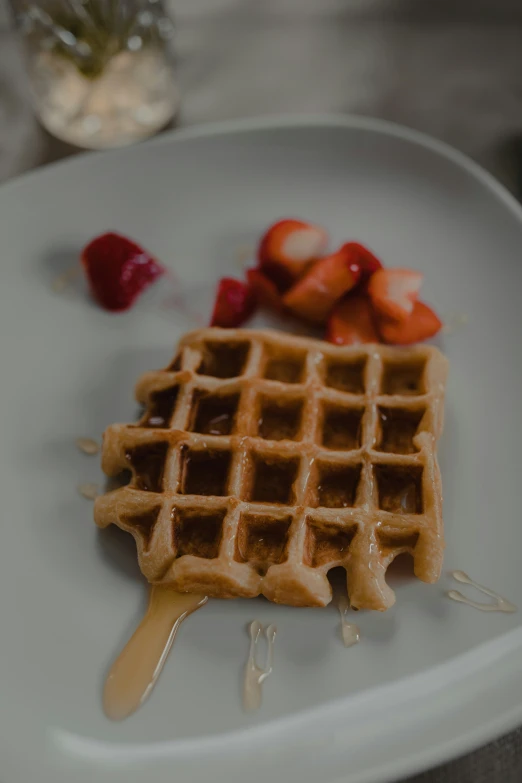 a waffle and strawberries is on a plate