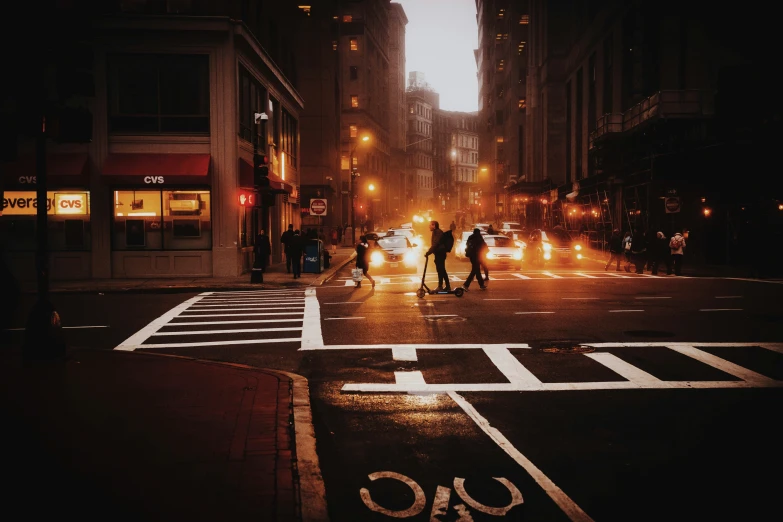 two people standing on the street near a cross walk in the middle of the night