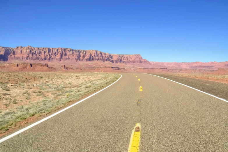 the road is empty with only two yellow lines in front